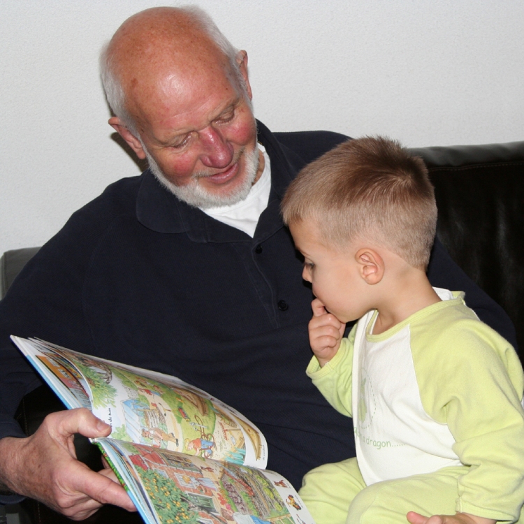 Ein älterer Mann zeigt einem Kind ein Buch